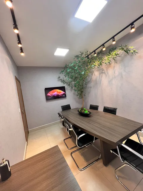 Sala de reunião da DCON em Goiânia, com mesa, cadeiras e televisor